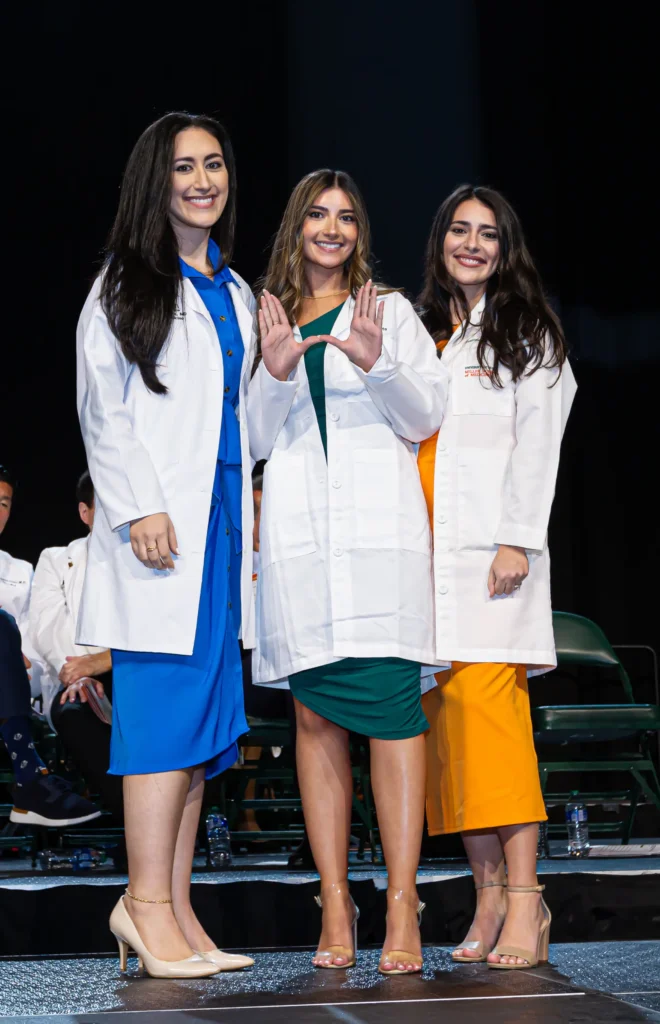 Gabriella Raffa, M.D.’17 (left) and Francesca Raffa, M.D. ’16 (right) pin sister Isabella Raffa, M.D. candidate, Class of 2027