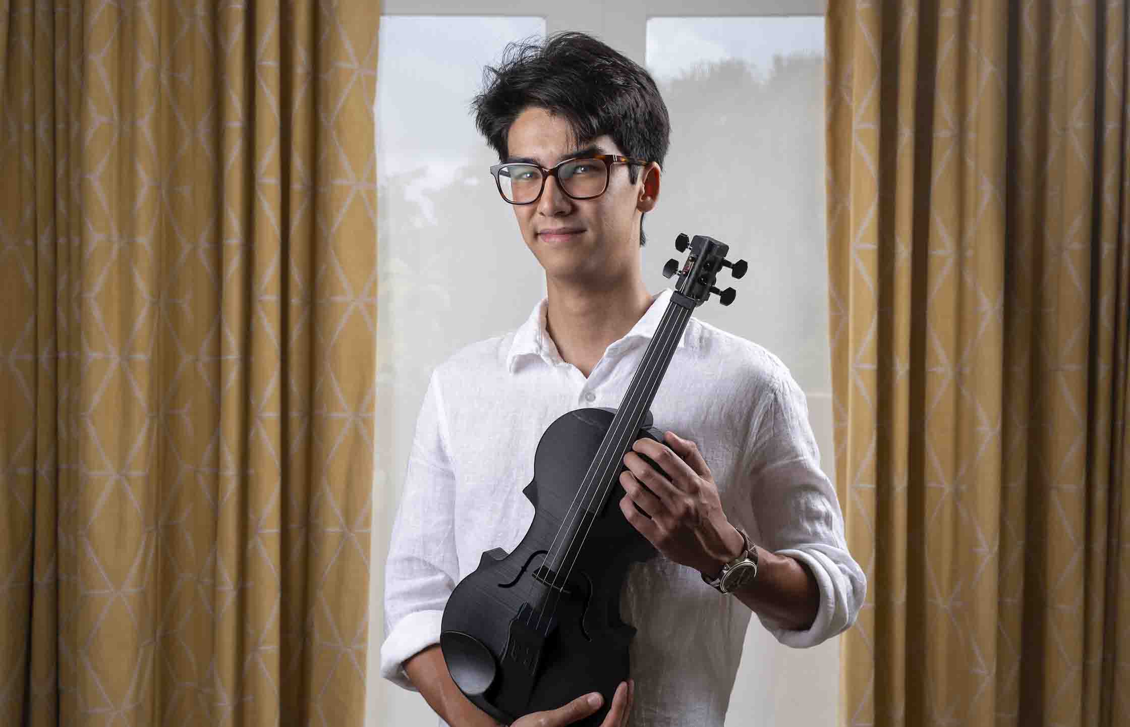 Ethan Tieu with one of his 3D-printed violins.