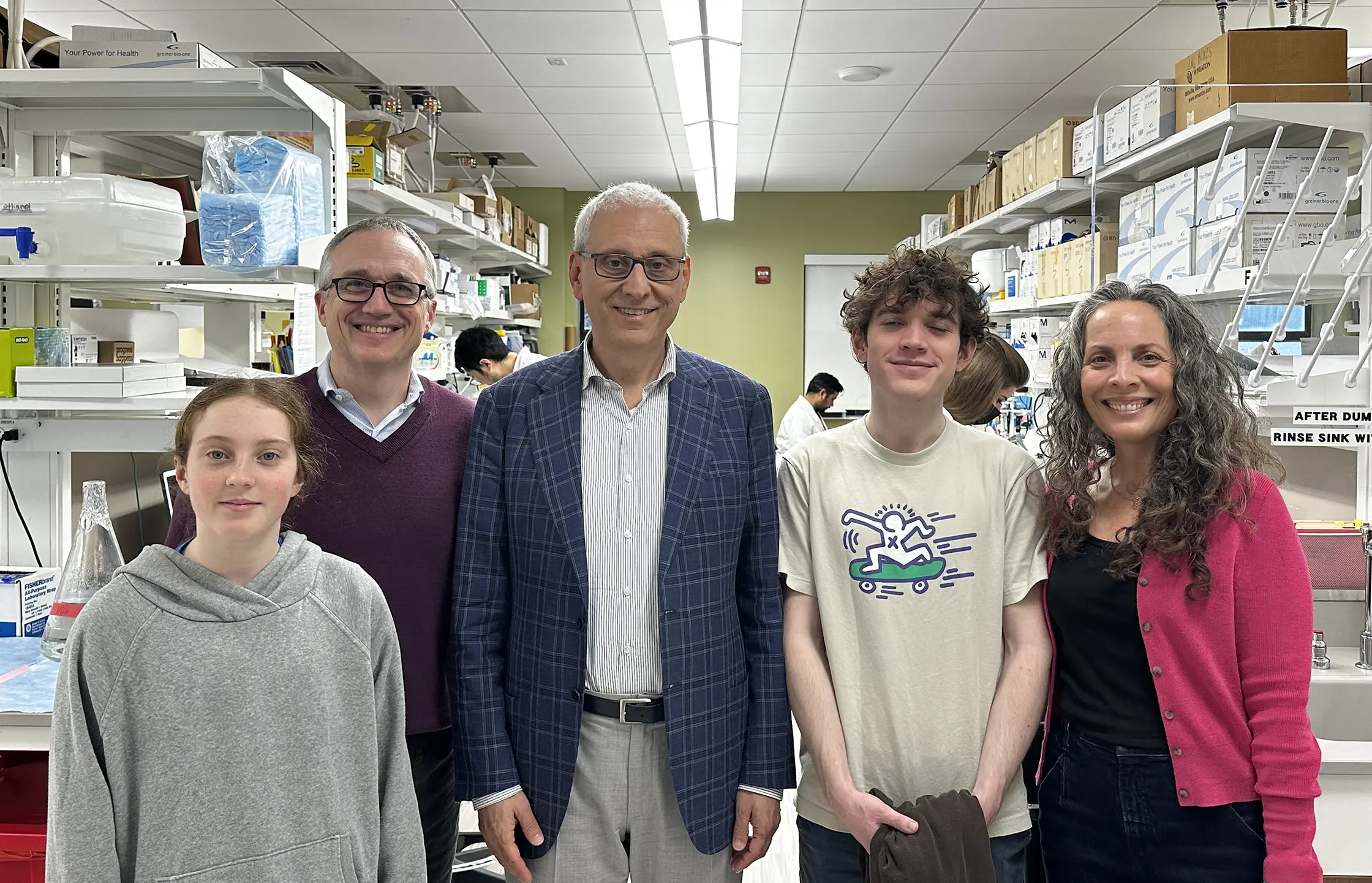 Antonio Iavarone, M.D. (center), giving the Prescott family a tour of his research laboratory.