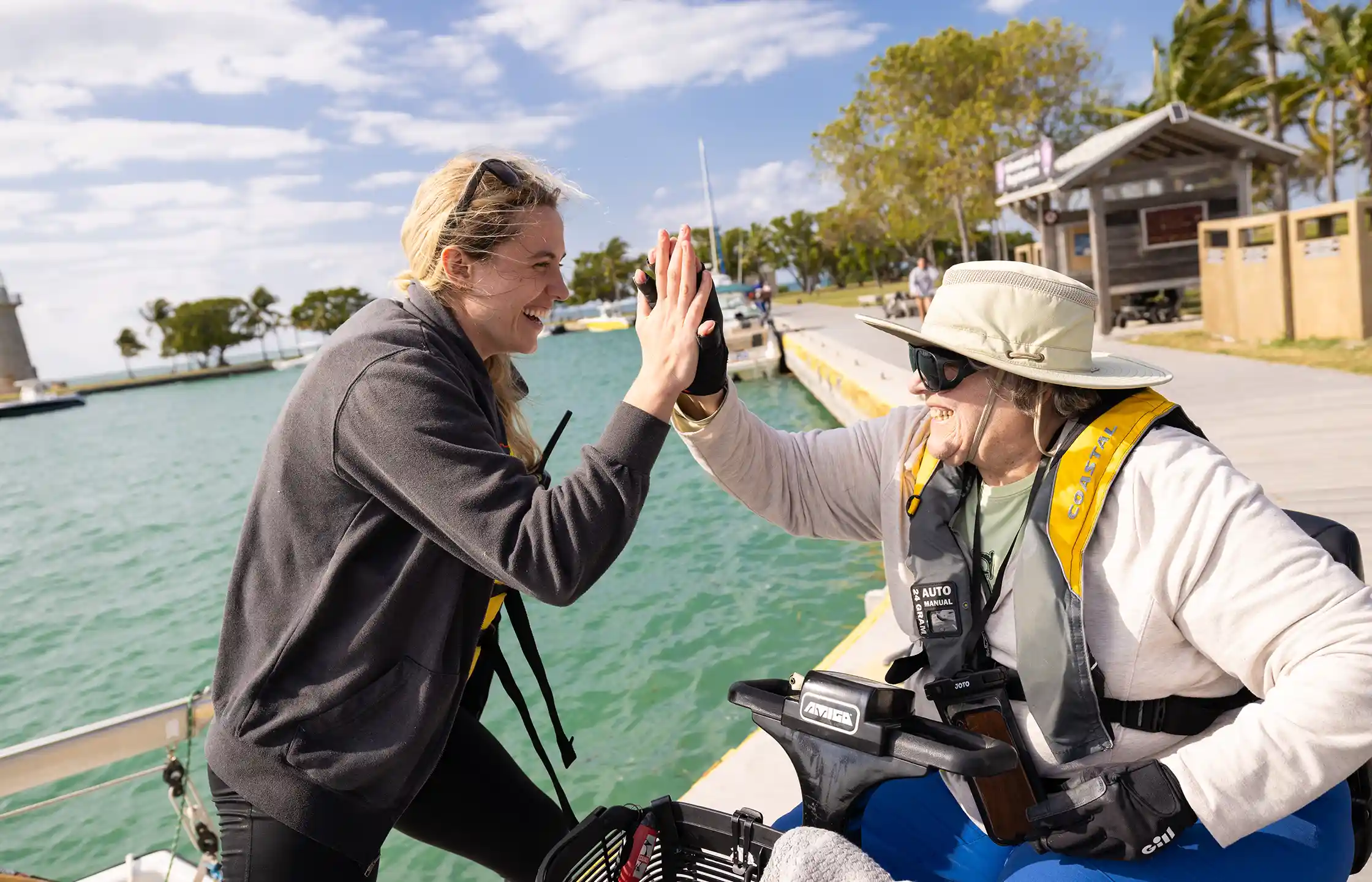 Student Kendall Riley, left, high-fives Patrick LoDuca following their five-hour sailing trip