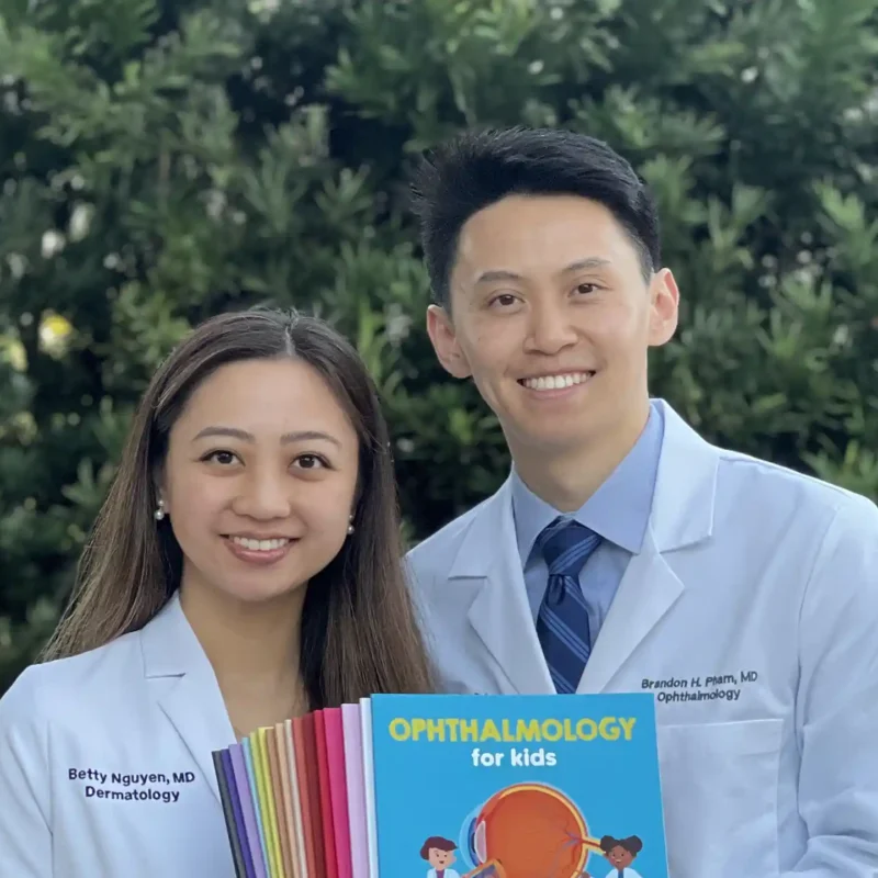 Physicians holding up children's books they worked on